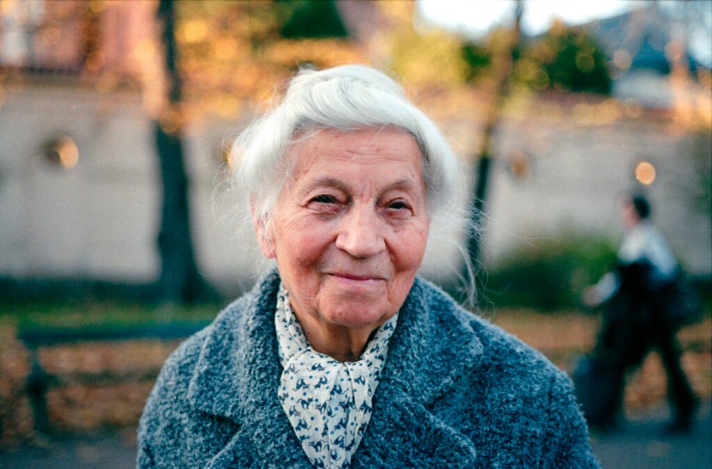 pexels photo 26692134 26692134 Portrait of a smiling elderly woman outdoors in Kraków during fall.